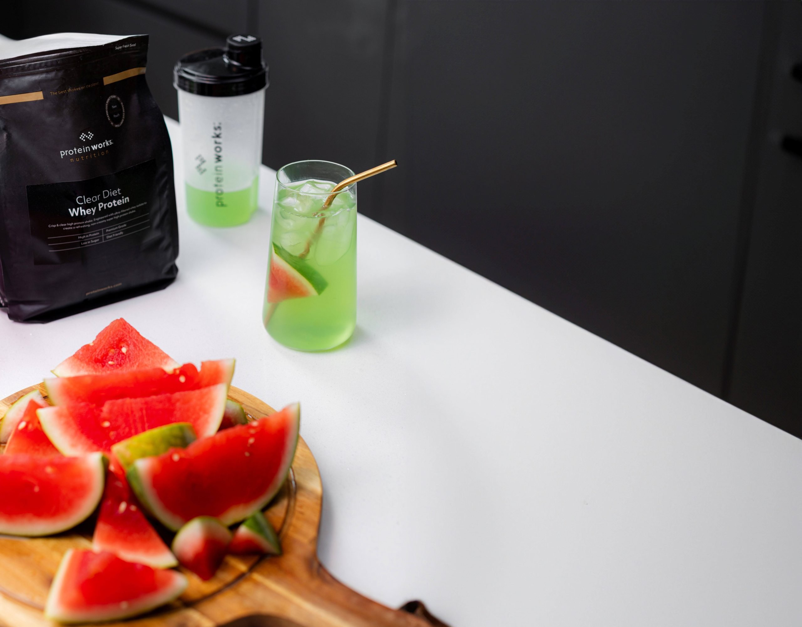A clear whey protein shake next to watermelon slices